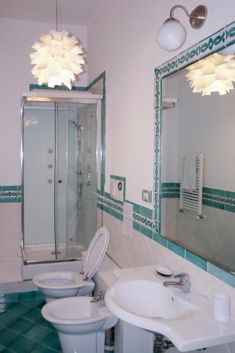 a bathroom with two sinks and a toilet and a mirror at Casa Maria Al Campo in Salerno