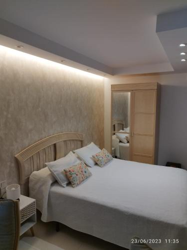 um quarto com uma grande cama branca e 2 almofadas em Estudio em Torrox Costa