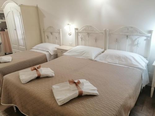 マテーラにあるNei pressi dei Sassiのベッドルームにタオル付きのベッド2台が備わります。