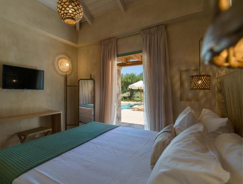 a bedroom with a bed and a view of a pool at Terra Oleana Cottages in Vasilikos