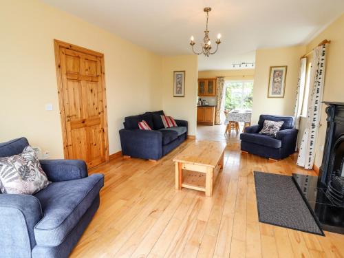 a living room with two blue couches and a fireplace at 29 Church Field in Doonbeg