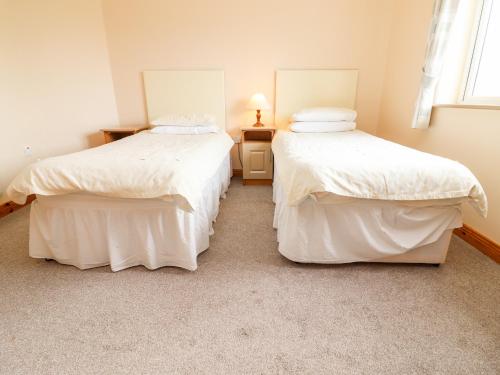 two twin beds in a room with aermottermottermott at 29 Church Field in Doonbeg