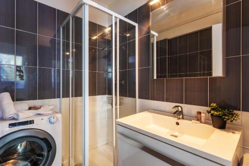 une salle de bain avec une machine à laver et un lavabo dans l'établissement BEAULIEU MARINONI AP4374 By Riviera Holiday Homes, à Beaulieu-sur-Mer