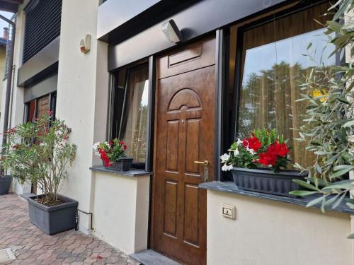 eine Holztür mit Blumen im Fenster in der Unterkunft Mysa Properties -Luminoso bilocale, Cormano in Cormano