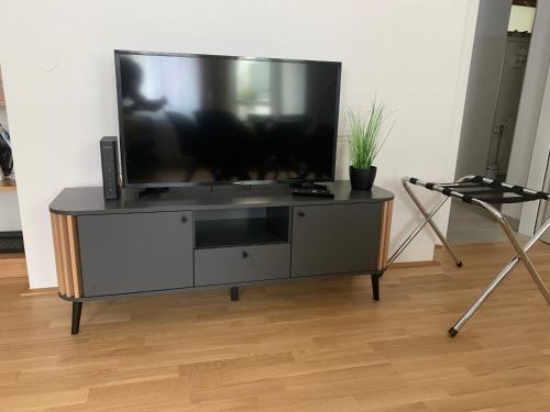 a flat screen tv sitting on a entertainment center at Air-conditioned, quiet apartment with a terrace in center of St Pölten - Smart TV in Sankt Pölten