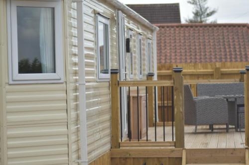 een tiny house met een terras en een veranda bij Lapwing Lodge in Louth