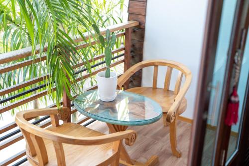 uma mesa e duas cadeiras numa varanda com uma planta em Madee Spa & Resort em Ban Khok Lo