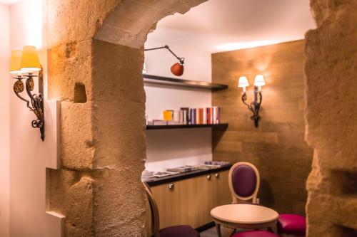 une salle avec un comptoir, une table et des chaises dans l'établissement Hotel Marais Grands Boulevards, à Paris