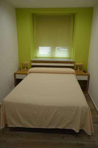 1 dormitorio con 1 cama blanca grande y ventana en Apartamentos Playas de Busto, en Busto