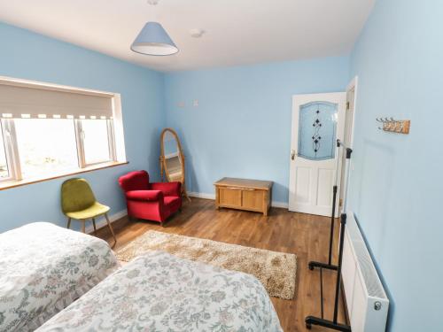 - une chambre avec deux lits et une chaise rouge dans l'établissement The Water's Edge, à Cavetown