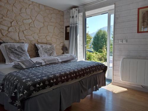 a bedroom with a large bed and a large window at CHALET HARMONIE in Auris
