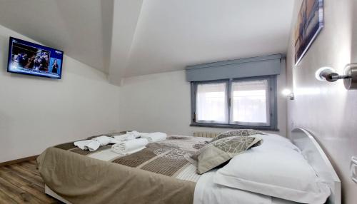 a bedroom with a bed with a tv on the wall at Guest Holiday Mandra 12 e 13 in Reggio Emilia