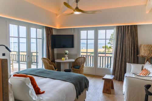 um quarto de hotel com uma cama e uma varanda em Résidence Les Suites Pereire em Arcachon