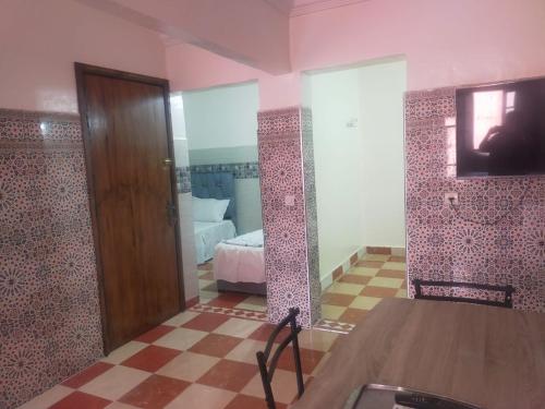 een kamer met een slaapkamer met een bed en een spiegel bij Appartement Relax Marrakech, شقة عائلية بمراكش متوفرة على غرفتين in Marrakesh