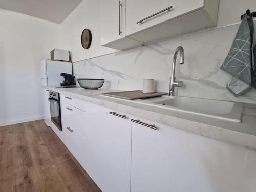 une cuisine avec des armoires blanches et un évier dans l'établissement Studio cosy cœur de ville, à Angers