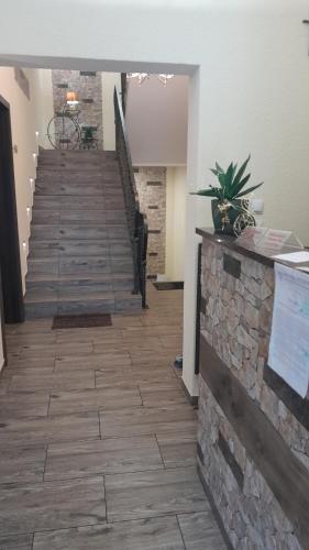 a lobby with a staircase with a stone wall at Apartamenty Puk Puk in Mrągowo
