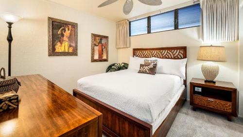 a bedroom with a bed and a table and a desk at Kona Reef A32 in Kailua-Kona