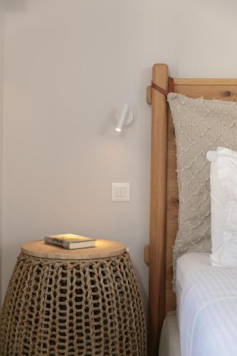 a table with a book on it next to a bed at Anapollo Boutique Hotel Adults Only in Naxos Chora
