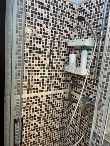 a bathroom with a shower with a tiled wall at Bungalow Carmen in San Bartolomé de Tirajana