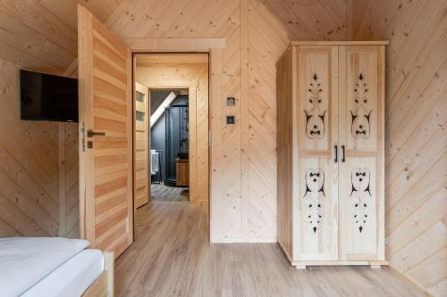 a bedroom with wooden walls and a door with faces on it at Osada Zbójnicka Turnia in Kościelisko