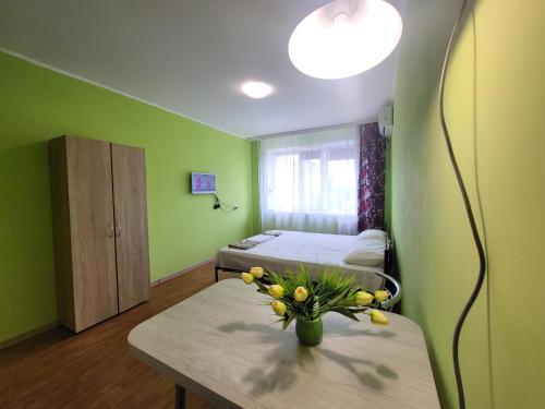 Квартира на Слобожанському Сomfort24 Slobozhansky 67 avenue في دنيبروبيتروفسك: غرفة بسريرين وطاولة مع إناء من الزهور