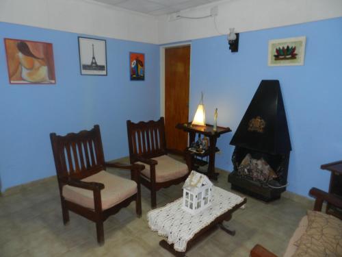 sala de estar con 3 sillas y chimenea en Lo de Lili en Puerto Madryn