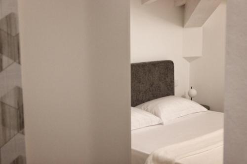 a bedroom with a white bed with a headboard at Villa Benatti in Carpi