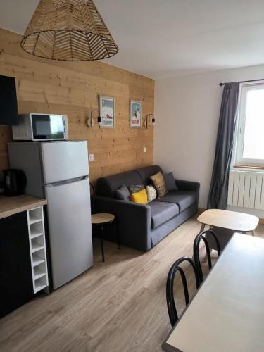 a living room with a couch and a table and chairs at Appartement 3 pièces, 2 chambres au cœur de la station in Val Louron