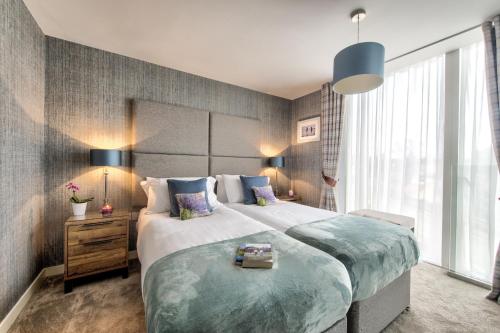 ein Schlafzimmer mit einem großen Bett und einem großen Fenster in der Unterkunft Luxurious apartment 10 minute walk from Old Course in St Andrews