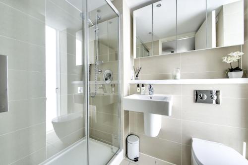 a white bathroom with a shower and a sink at Luxurious apartment 10 minute walk from Old Course in St Andrews