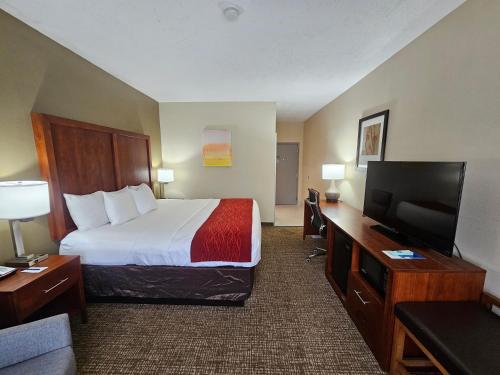 a hotel room with a bed and a flat screen tv at Comfort Inn Jackson I-40 in Jackson