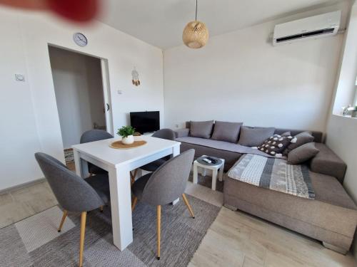 a living room with a couch and a table and chairs at Apartman REA 1 in Pirot