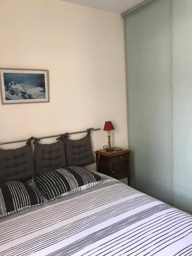 - une chambre avec un lit et une couverture rayée dans l'établissement Chambre Haute mer, à Montpellier