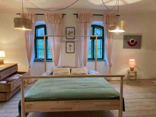 a bedroom with a bed in a room with windows at House by the Church - entire house in Criţ