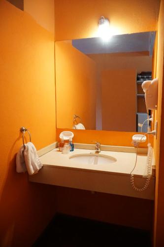 a bathroom with a sink and a mirror at Hotel El Cid in Villa Carlos Paz