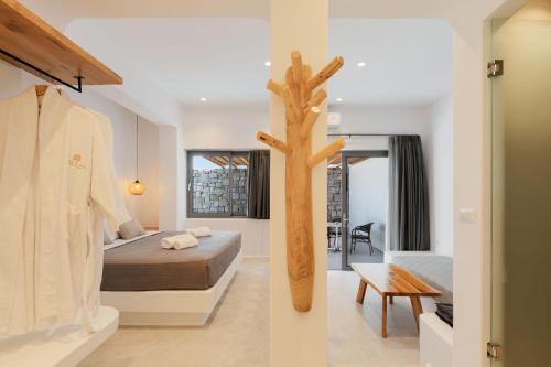 a bedroom with a tree in the middle of it at Sunset Hill Suites in Mýkonos City