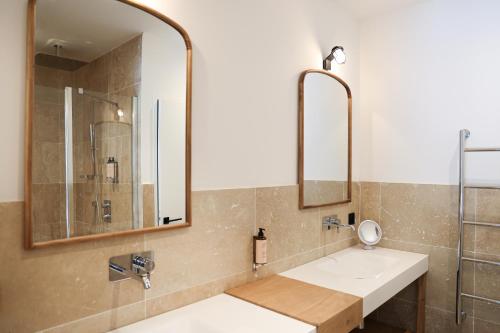 W łazience znajduje się umywalka i lustro. w obiekcie Résidence Les Suites Pereire w Arcachon