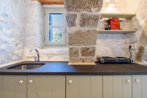 a kitchen counter with a sink and a window at Apostrophe Traditional Residence in Nisyros with arcurated interior. Privacy & Authenticity in Emporeiós
