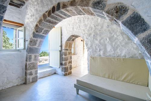 a room with a stone wall and a bench at Apostrophe Traditional Residence in Nisyros with arcurated interior. Privacy & Authenticity in Emporeiós