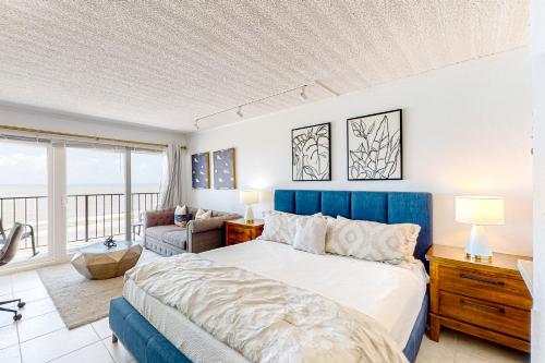 Schlafzimmer mit einem großen Bett mit blauem Kopfteil in der Unterkunft Ocean Escape By the Sea in Galveston