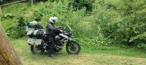 a person on a motorcycle parked in the grass at Holiday bungalows Pajkovir in Kolašin