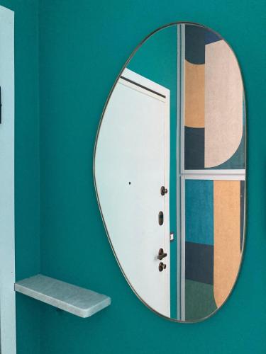 a mirror on a green wall with a door at The Silky Way relax e quiete in prossimità di lago e città in Como