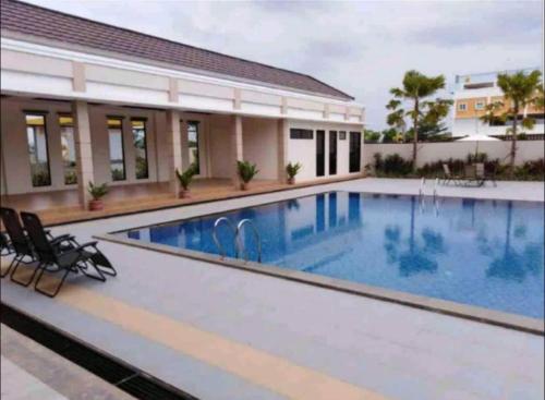 a large swimming pool with chairs next to a building at Monde Residence H 15 Batam Centre in Sengkuang