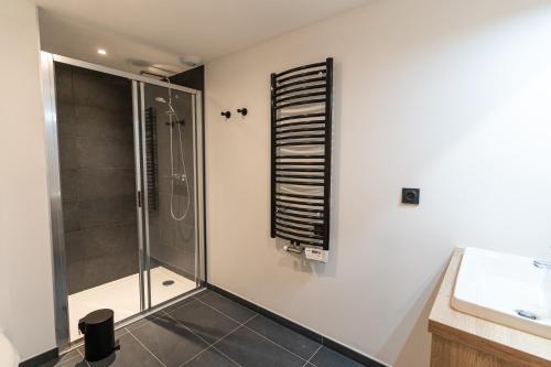 ein Bad mit einer Dusche und einer Glasduschkabine in der Unterkunft Roches Blanches by Daddy Pool - TERRESENS in Combloux