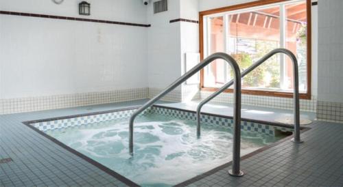 uma banheira de hidromassagem numa casa de banho com janela em Cahilty Hotel & Suites em Sun Peaks