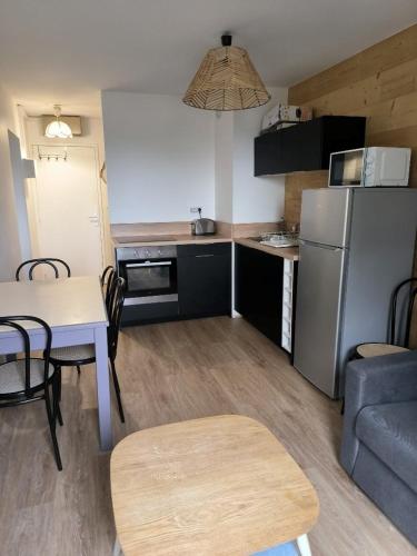 a small kitchen with a table and a refrigerator at Appartement 3 pièces, 2 chambres au cœur de la station in Val Louron