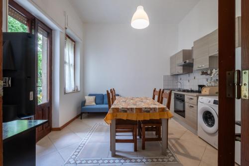 a kitchen with a table and chairs in a room at Maison Adriana con giardino - 10 minuti dal Poetto e dal Parco Molentargius in Quartu SantʼElena
