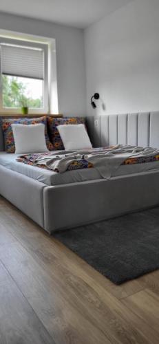 un grande letto in una camera da letto con un piano di Apartament pod Grodziskiem 
