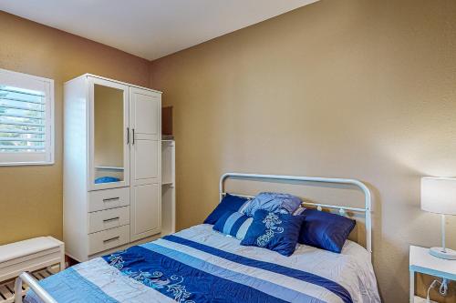 um pequeno quarto com uma cama com almofadas azuis em Quaint and Quiet em Santa Clarita