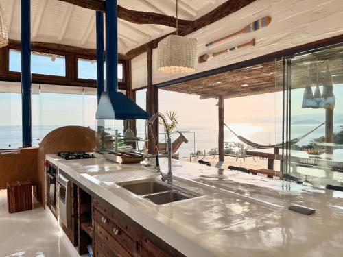 a kitchen with a sink and a view of the ocean at Blow Show Casa III Guest House in Ilhabela